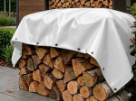 Bâche sur mesure couvrant un tas de bois de chauffage à l'extérieur, bâche blanche avec oeillets de fixation.