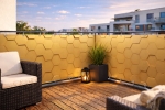 Gouden balkonafscheiding op maat met honingraatstructuur gemonteerd op een modern terras met uitzicht.