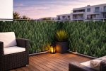 Custom-made Raster balcony screen with forest print, mounted on a terrace railing with garden furniture.