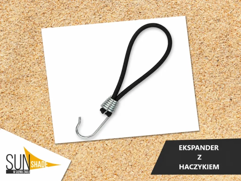 Black rubber expander with a plastic hook for securing sun sails against a sand background.