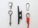 Conjunto de acessórios náuticos: roldana, cunho preto, mosquetão, olhal e corda vermelha com sapatilho.