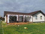 Cortina blanca para cenador Premium colgada en la terraza de madera de una moderna casa unifamiliar con jardín.