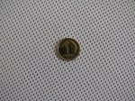 Una moneda de 1 grosz sobre el material blanco de una franja de parasol para cenador con estructura de malla fina.