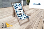 Teras üzerinde geometrik desenli ve ME & YOU yazılı ahşap reklam şezlongu. Köşede Sun Shade logosu.