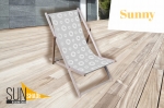 Liggestol i træ med gråt stof med hvide cirkelmønstre på en terrasse, reklame-liggestol af typen Sunshade Sunny.