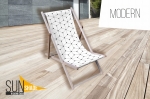 Șezlong din lemn cu pânză albă cu model geometric modern pe o terasă. Produs marca Sun Shade.