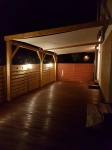Elegant waterdicht premium schaduwdoek 4x4 gemonteerd op een houten pergola boven het terras met nachtverlichting.