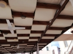 Vodotesný altánkový pás 0,4x5 m v krémovej farbe, namontovaný na drevenej konštrukcii zastrešenia terasy.