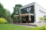 Οριζόντιο ρωμαϊκό στόρι premium Decor 3x4 m τοποθετημένο σε κατασκευή μοντέρνας βεράντας δίπλα σε σπίτι.