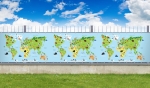 Balkonscherm op maat met kindermotief wereldkaart en dieren tegen een blauwe lucht met wolken.