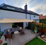 Balcony with furniture situated under a custom-made rectangular HDPE sun sail.