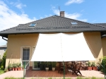 Hvit vanntett uttrekkbar solseil 1,5x5 m montert som terrassetak på en enebolig.