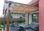 Wasserbedecktes, ausziehbares Sonnensegel 3x5 m in Beige, montiert auf einer Holzpergola über der Terrasse.