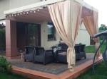 Μπεζ οριζόντιο premium ρωμαϊκό στόρι Decor 3x4 τοποθετημένο σε ξύλινο κιόσκι βεράντας με έπιπλα κήπου.
