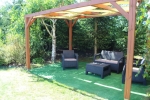Bruine houten tuinpergola met gemonteerde horizontale HDPE-zonnecollectorstrook van 0,5x5 m.