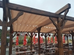 Οριζόντια ρωμαϊκή κουρτίνα Premium Decor 2,5x3 m τοποθετημένη σε ξύλινη πέργκολα πάνω από βεράντα εστιατορίου.