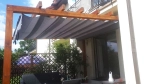 Οριζόντια ρωμαϊκή κουρτίνα premium Decor διαστάσεων 2,5x3 m τοποθετημένη σε ξύλινη πέργκολα βεράντας.
