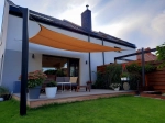 Voile d'ombrage HDPE sable 3x4 m installée sur la terrasse d'une maison moderne avec jardin.
