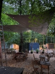 Custom-made waterproof industrial garden sail shading a café garden in the forest.
