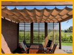 Οριζόντια ρωμαϊκή blind premium Decor 2,5x3 που προστατεύει από τον ήλιο έπιπλα κήπου κάτω από ξύλινη πέργκολα.