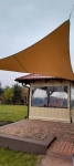 Custom-made waterproof garden sail installed over a gazebo, protecting against rain and sun in the garden.