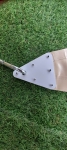 Corner of a waterproof sun sail with a white mounting plate and a sturdy metal carabiner.