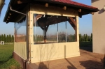 Cobertura de terraço transparente por medida com rebordo bege, montada num gazebo de madeira.