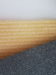 Schuifbaar HDPE schaduwdoek op maat in geel en grijs, zichtbare dichte structuur van het materiaal.