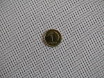 Close-up van het witte mesh-weefsel van een budget schaduwdoek met een munt van 1 grosz om de maaswijdte te tonen.
