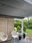 Kış bahçesi için özel ölçülü gri gölgelik, bahçe manzaralı teras çatısı altına monte edilmiş.