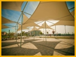 Modern industrial-grade custom-made shade sails, creating a geometric canopy over a city square.