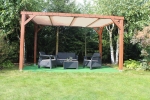 Houten pergola met tuinmeubilair en gemonteerd HDPE schaduwdoek op maat in crème kleur.