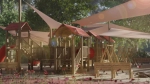 Houten kinderspeelplaats in de schaduw van op maat gemaakte driehoekige schaduwdoeken in de kleur beige.