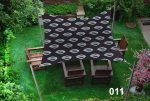 Voile d'ombrage carrée imperméable 3x3 m aux motifs géométriques, installée au-dessus de meubles de jardin en bois sur une pelouse.
