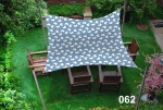 Waterproof 3x3 m garden sail in a grey geometric pattern over wooden armchairs in the garden.