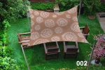 Vela ombreggiante marrone impermeabile 3x4 con motivo floreale bianco sopra mobili da giardino in legno sul prato.
