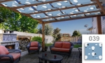 Zonnedoek voor overkapping op maat met ballonmotief, gemonteerd op een houten pergola boven een terras met tuinmeubelen.
