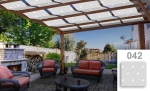Witte zonnebaan voor paviljoen met stippen, gemonteerd op een houten pergola boven een terras met meubels.