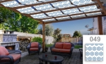 Maatwerk zonne-overkapping met blauwe ruiten boven een tuinmeubelset op een terras met open haard.