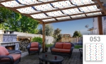 Op maat gemaakte zonneband voor prieel met patronen op een terras met tuinmeubilair en buitenhaard.