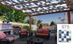 Maatwerk zonnedoek voor overkapping in blauw-grijze ruiten op een modern terras met meubels en open haard.