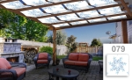 Grafische zonneschermbaan op maat met blauw plantenmotief, gemonteerd op een houten pergola.