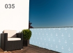 Custom-made light blue balcony privacy screen with a white anchor motif on a terrace with a wicker chair and a plant.