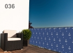 Balcony privacy screen with a white anchor motif on a navy blue background mounted on the railing of a modern terrace.