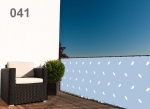 Light blue raster balcony screen with a white pattern mounted on a terrace railing with garden furniture.