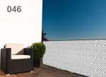 Patterned balcony screen with a diamond motif on a modern balcony with a dark armchair and green shrub.