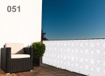Balkonafscherming raster nr. 051 met geometrische patronen, gemonteerd op een balkon met een zwarte fauteuil en plant.