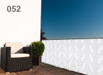 Witte balkonafscherming op maat met geometrisch honingraatpatroon, gemonteerd aan de terrasrailing bij een fauteuil.