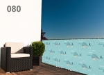 Balkonhekbekleding op maat met een prachtig blauw walvismotief, gemonteerd op een terrasreling naast een zwarte fauteuil.