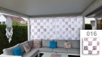 Custom-made net curtain with a pink geometric pattern on a terrace with a corner sofa and decorations.